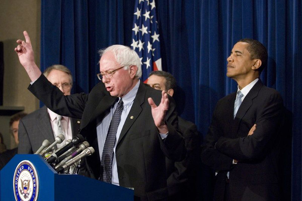Barack Obama stands behind Bernie Sanders in a 2007 photo.