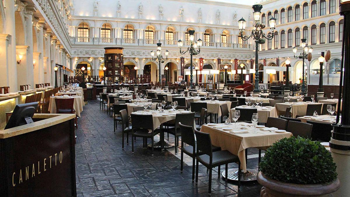 An indoor patio with a replica of St. Mark’s Square in the background. 