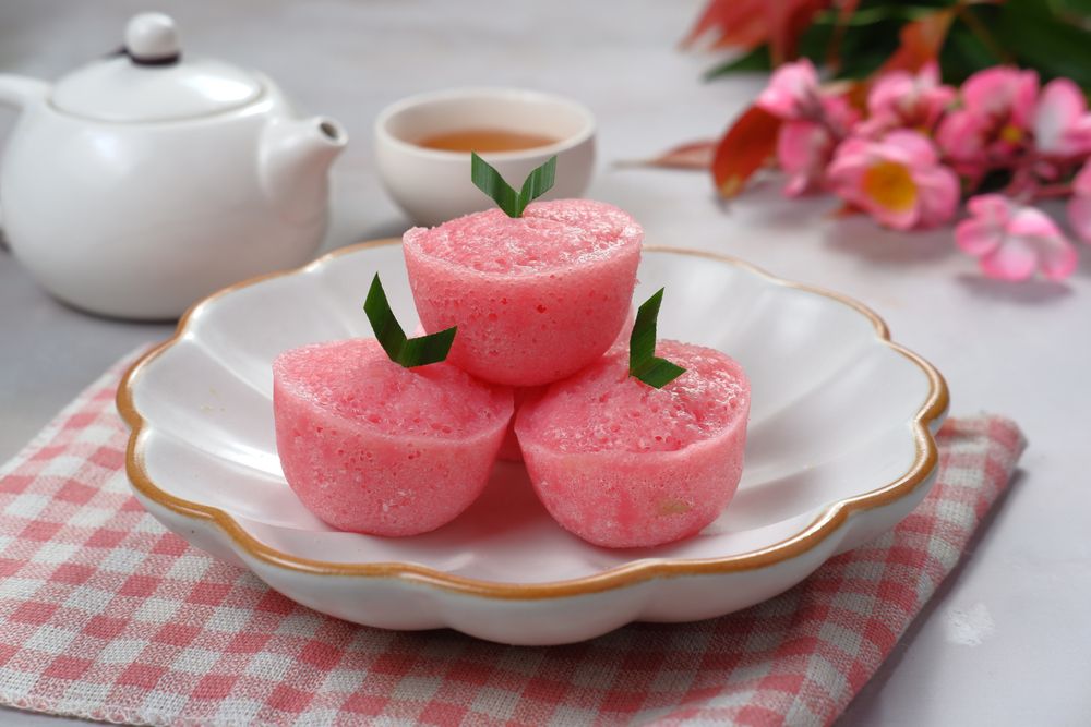 Pink cakes with green garnish on a decorated plate.