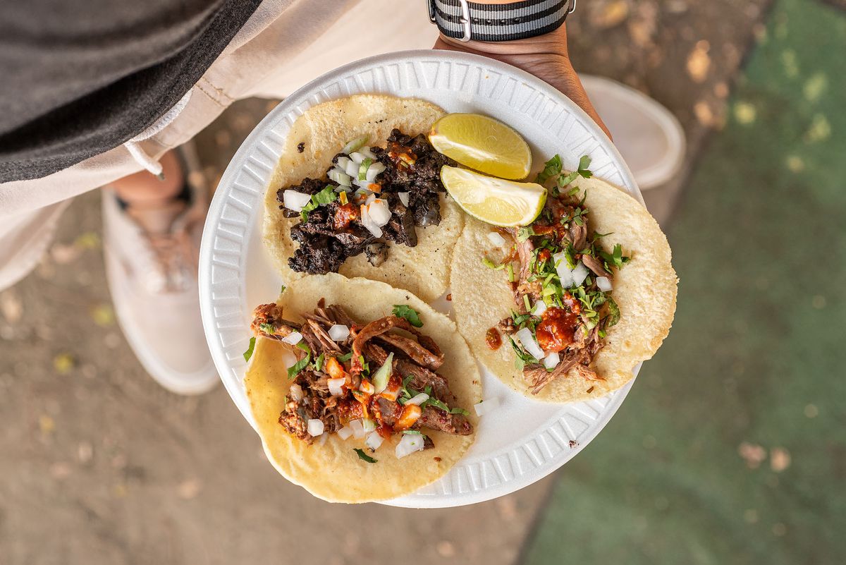 Moronga and barbacoa tacos on a paper plate.