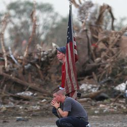 People react in front of the Towers Plaza Elementary school in Moore following a deadly tornado, Monday, May 20, 2013. 