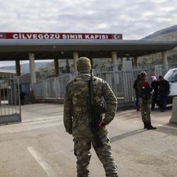 A Turkish soldier provides security at the Cilvegozu border gate with Syria, near Hatay, southeastern Turkey, Sunday, Dec. 18, 2016. Several Syrian people were able to cross into Turkey after they managed to leave the embattled Syrian city. The Aleppo evacuation was suspended Friday after a report of shooting at a crossing point into the enclave by both sides of the conflict. 