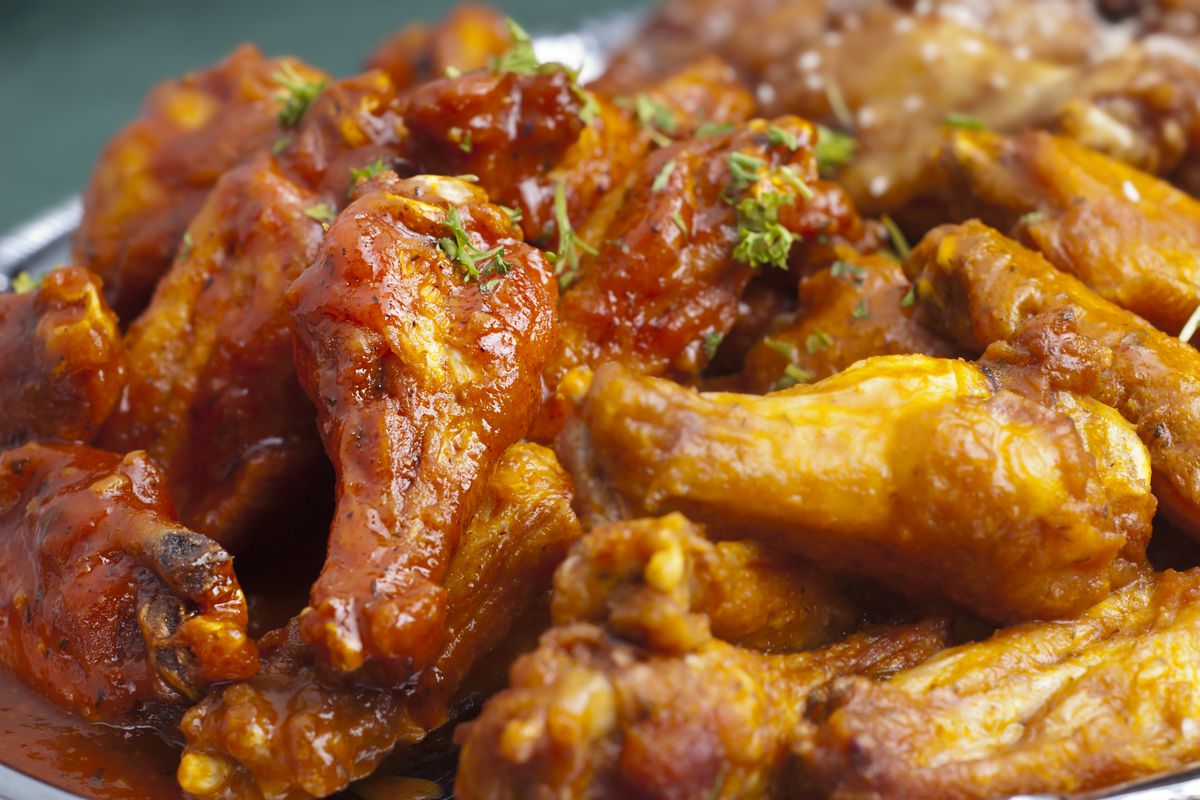chicken wings, up close, covered in buffalo sauce.