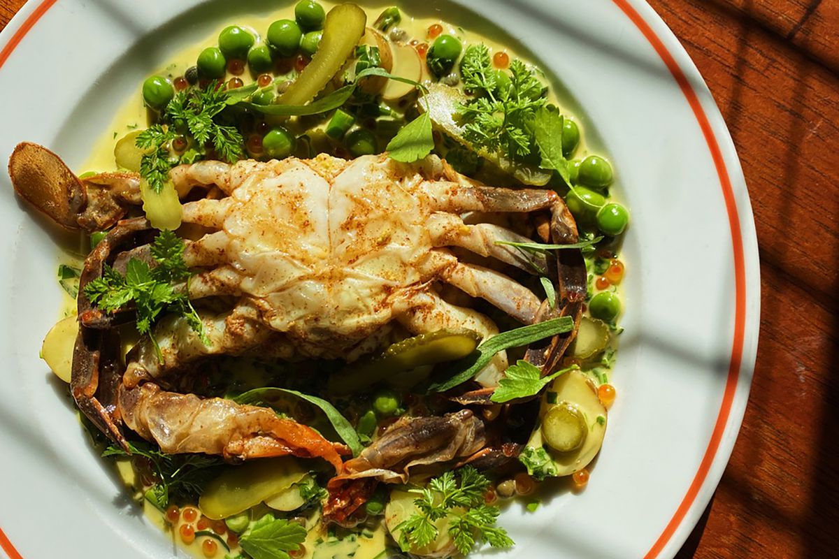 A soft shell crab on top of peas and pickles.