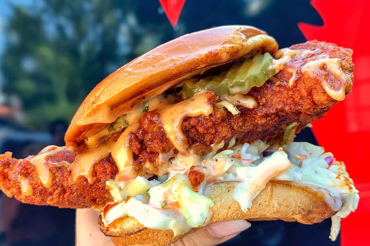 a cripsy breaded chicken on a bun with cole slaw and pickles