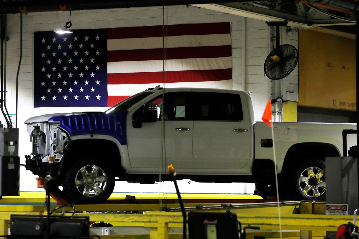 A Chevy truck is half assembled and sitting in front of an American flag in Flint, Michigan.