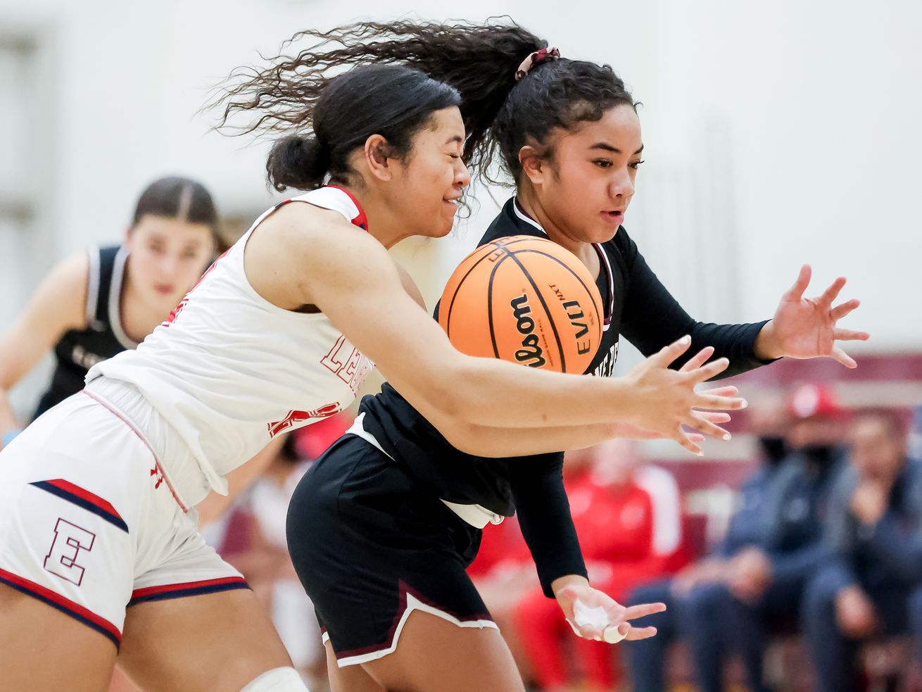 East’s Sila Tuakoi and Lone Peak’s Makeili Ika chase the ball in a girls basketball game at East High School in Salt Lake City on Tuesday, Dec. 7, 2021.