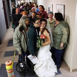 Jax Collins, left, hugs Heather Collins as they wait to get a marriage license outside the Salt Lake County clerk's office, Monday, Dec. 23, 2013. U.S. District Judge Robert Shelby denied a motion by the state of Utah to halt same-sex marriages pending an appeal.