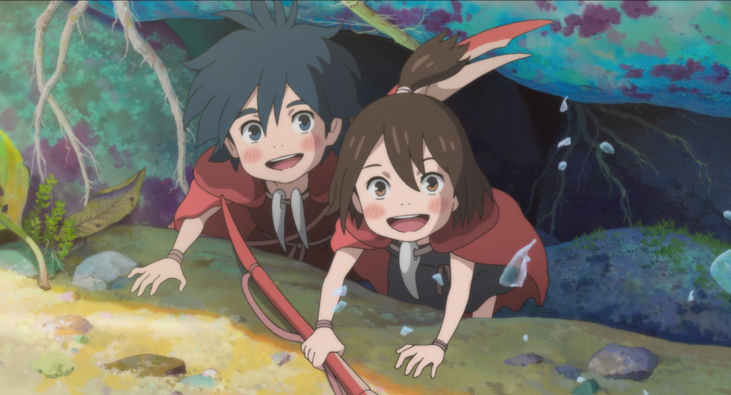 A blue haired anime boy and a brown haired anime girl wearing red cloaks smile from beneath a rock in the ocean.