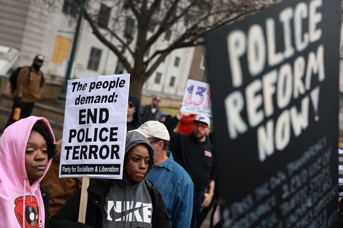 Protesters hold up signs saying “End police terror” and “Police reform now!”