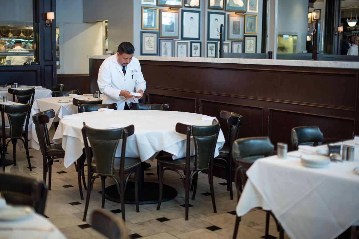 A server sets down napkins at a fine dining restaurant in prep for service.