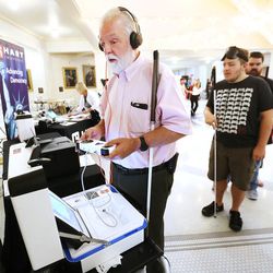 Karl Smith, who is visually impaired, tries out the Verity voting system from Heart Intercivic at the state Capitol in Salt Lake City on Wednesday, Aug. 2, 2017. Members of the public will be able to try out five different machines the state is considering buying.