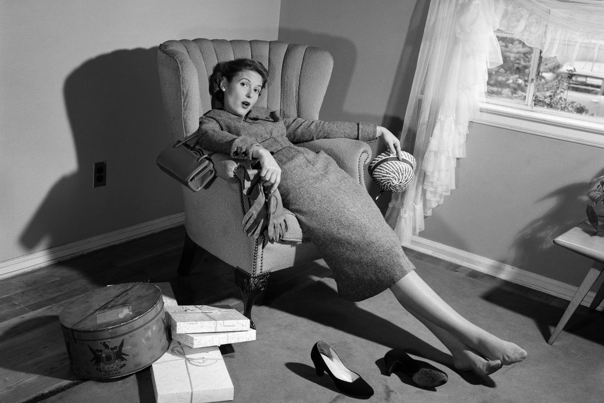 A 1950s woman slumped on a chair, exhausted from shopping