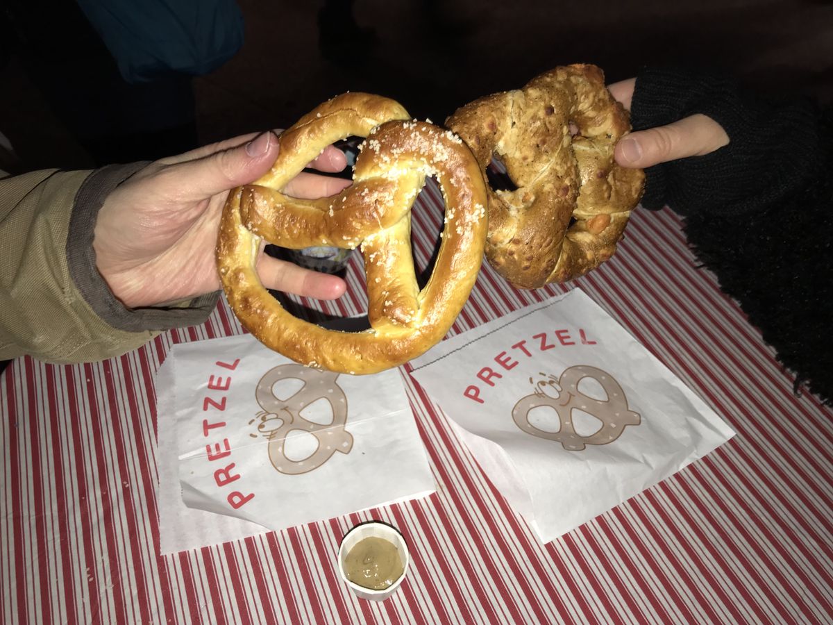 A hand holding a pretzel.