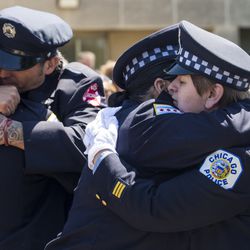 Mourners hug after the funeral for Juan Bucio at St. Rita of Cascia High School, Monday, June 4, 2018. Bucio, a CFD diver, died on Memorial Day while conducting a search in the Chicago River. | Ashlee Rezin/Sun-Times