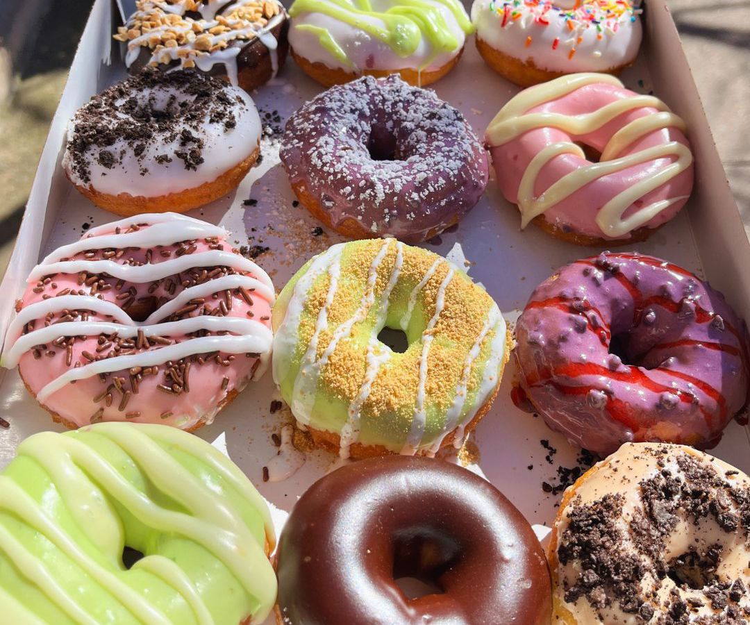 A box of colorful decorated donuts.