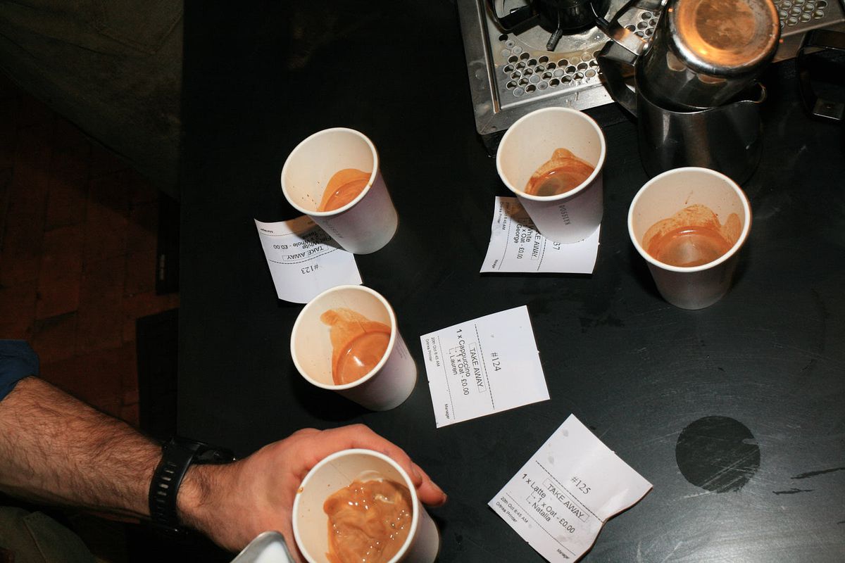 Five coffee cups full of espresso with matching dockets.