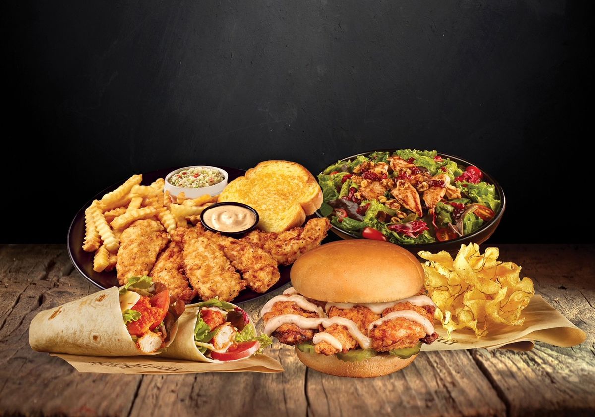 A spread of chicken tenders, sandwiches, and salad.