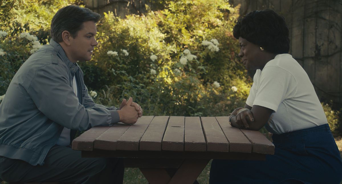 Matt Damon’s Sonny Vaccaro sits across from Viola Davis’ Deloris Jordan at a backyard picnic table in the film Air.
