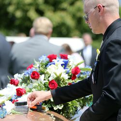 Tyson Ricks places tools on the casket of his father at funeral services for Kay Ricks at Lehi City Cemetery on Saturday, May 28, 2016. Ricks was a UTA employee who vanished while on the job and was found dead in Wyoming on May 17.