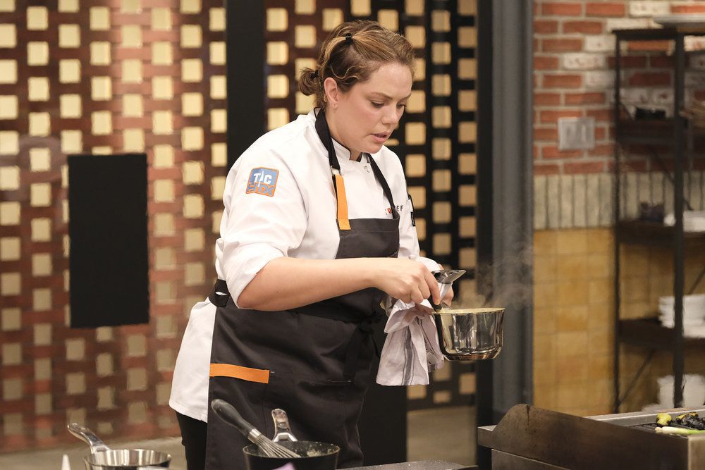 Chef Stephanie Miller holds a steaming pot of cheese.