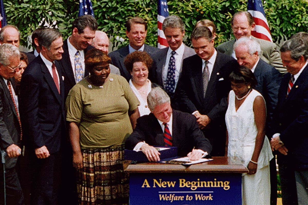 Lillie Harden stands alongside President Bill Clinton as he signs welfare reform into law.