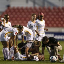 Utah Royals FC midfielder Gunnhildur Jónsdóttir (66) is attended to by medical personal and teammates after she was injured by the Seattle Reign FC during their match at Rio Tinto Stadium in Sandy on Friday, June 28, 2019.