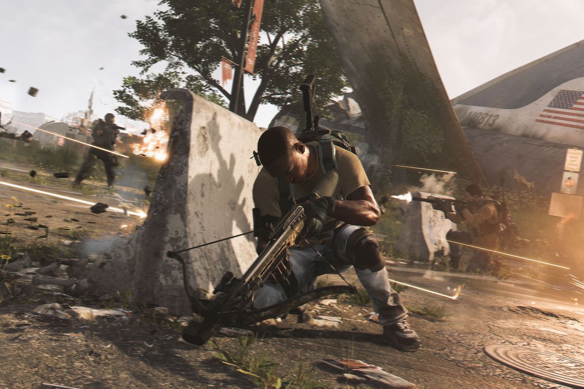 a soldier crouching behind a barrier to avoid gunfire in The Division 2