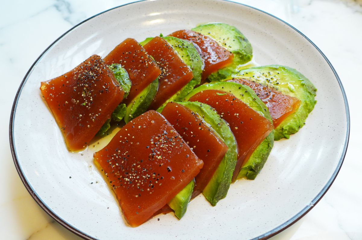 Stacked planks of red jelly lined with avocado.