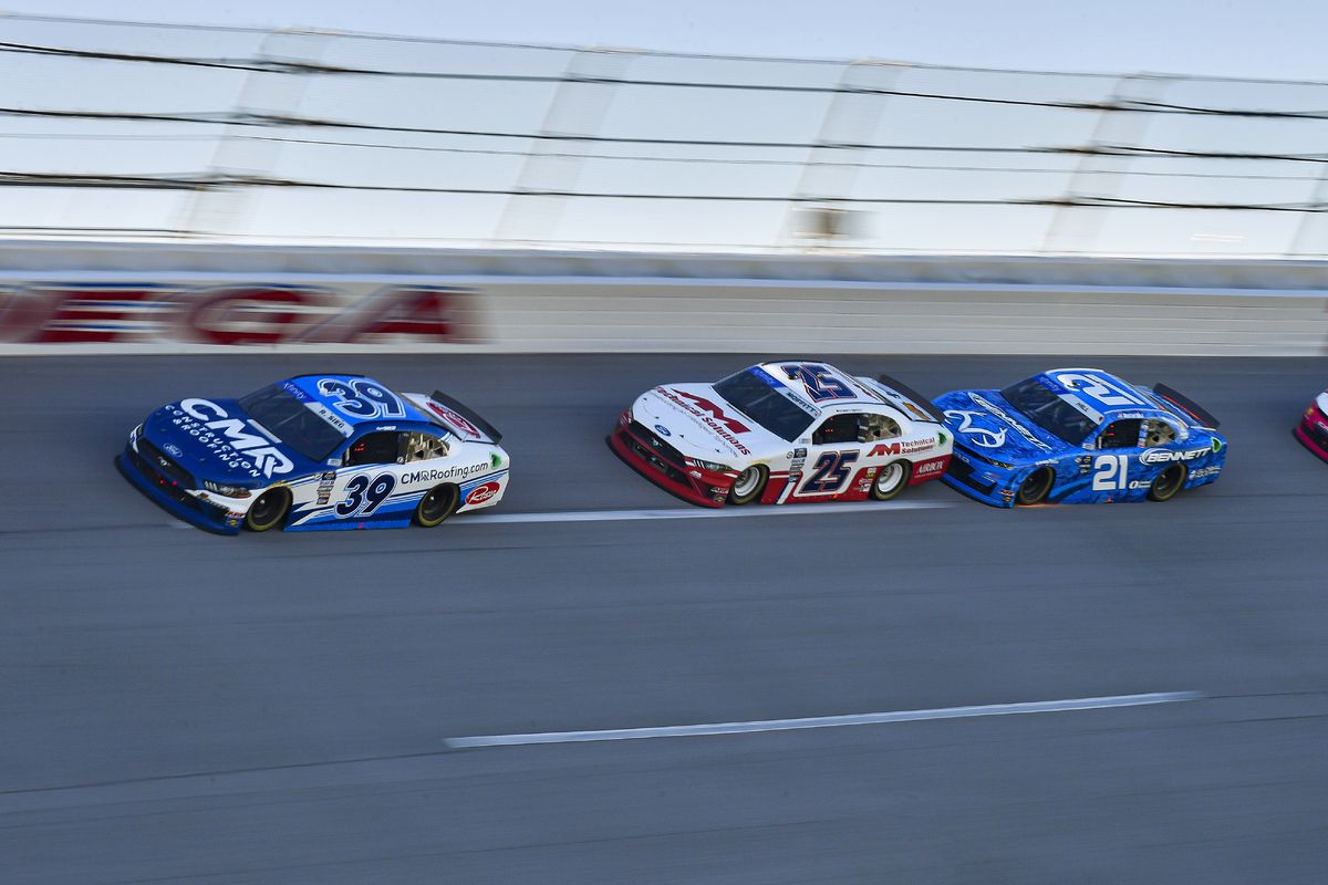 Ryan Sieg of the CMRRoofing.com Ford (39), Brett Moffitt of the AM Technical Solutions Ford (25) and Austin Hill of the Bennett/Realtree Chevrolet (21) race through turn four during the Ag-Pro 300 in the NASCAR Xfinity Series on April 22, 2023 at Talladega Superspeedway in Lincoln, AL.