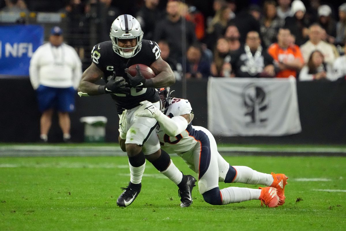 Las Vegas Raiders running back Josh Jacobs (28) is defended by Denver Broncos inside linebacker Baron Browning (56) in the first half at Allegiant Stadium.