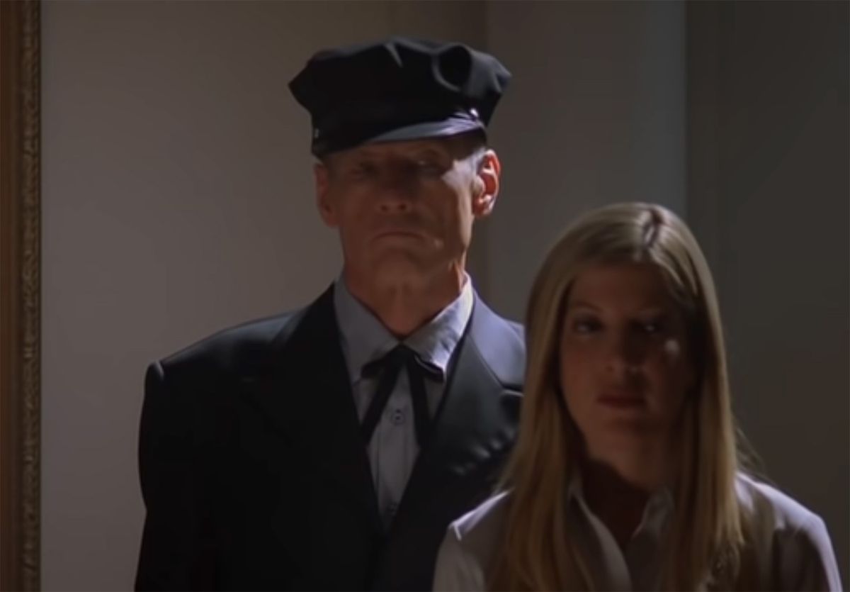 A prison guard stands behind Tori Spelling