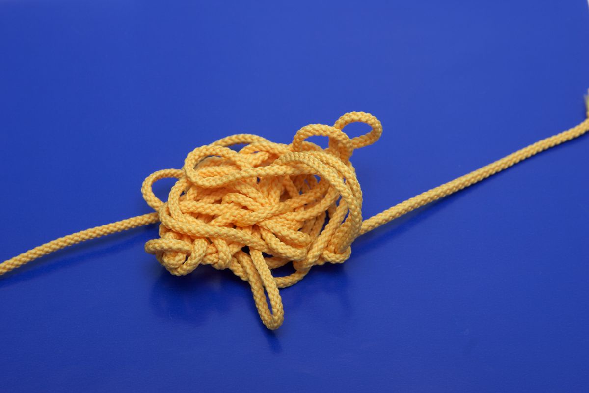 A tangled bit of thin yellow rope, with one end leading off to the left and the other end off to the right.