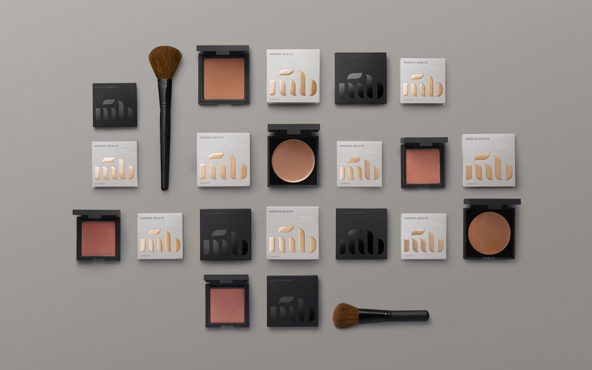 Blushes and blush packaging laid flat with blush brushes.