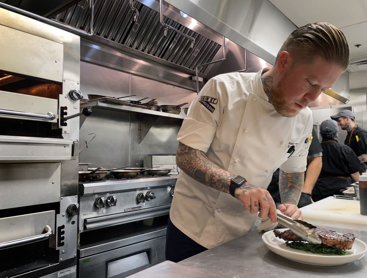 Chef Patrick Munster plates a steak in the kitchen of Main St. Provisions.