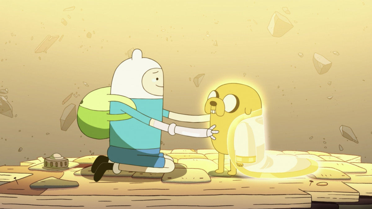finn embracing jake, who has a gold cloak draped over his shoulders