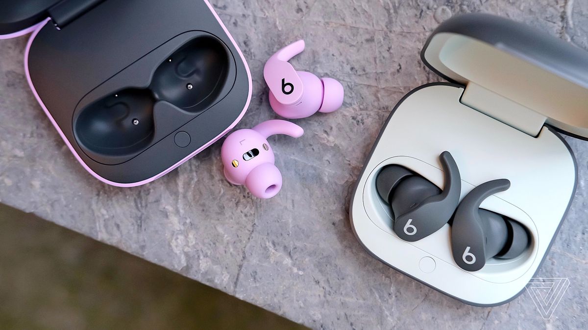 A photo of two pairs of Beats Fit Pro earbuds on a marble surface.