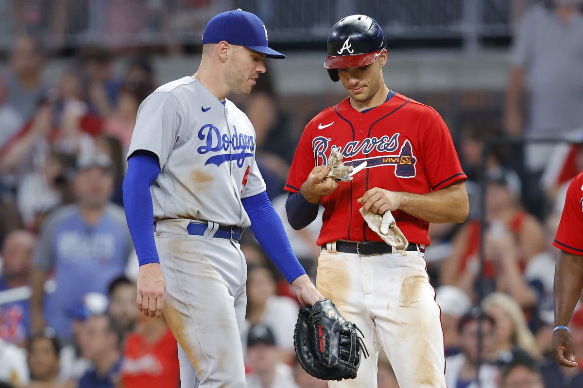 Matt Olson #28 of the Atlanta Braves stands at first base with Freddie Freeman #5 of the Los Angeles Dodgers during the ninth inning at Truist Park on June 24, 2022 in Atlanta, Georgia.