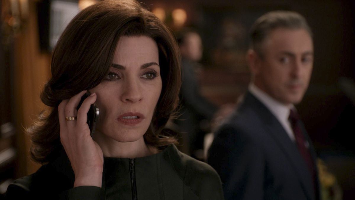 Julianna Margulies holds a cell phone to her ear while Alan Cumming watches behind her in The Good Wife.