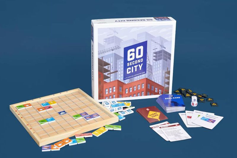 The components of 60 Second City and its box laid out on a blue background.