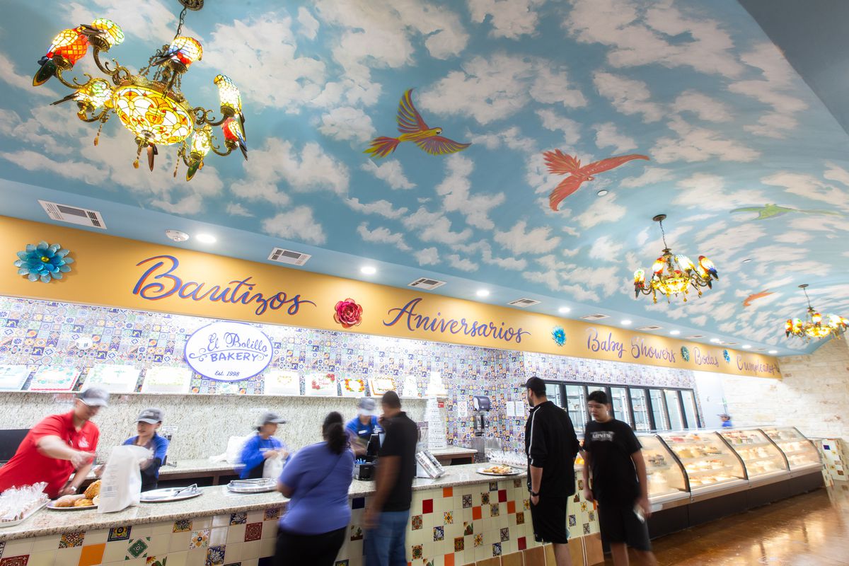 El Bollio Bakery’s ceiling is decorated with a handpainted mural of the sky and bird light fixtures.