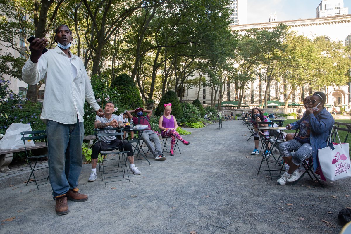 Marcus Moore, left, speaks to a group of fellow homeless people in Bryant Park about how to pressure the city to pay for hotel rooms they’ve been staying in during the pandemic, on July 15, 2020.