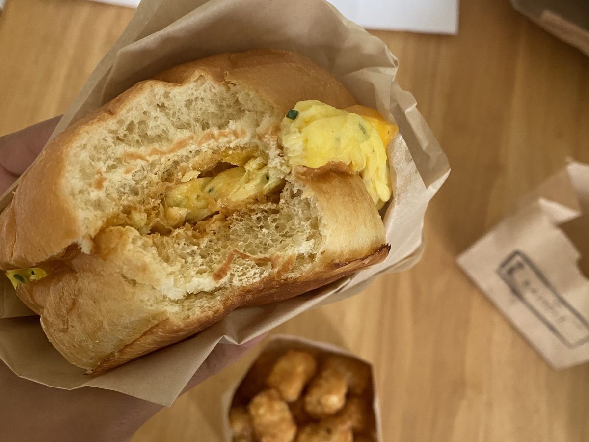 A vegetarian breakfast sandwich with tater tots.