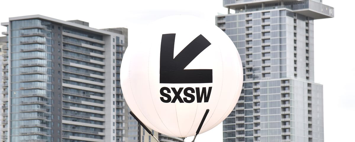 A large white balloon with an arrow pointing to the bottom left and words reading SXSW in front of a city skyline.