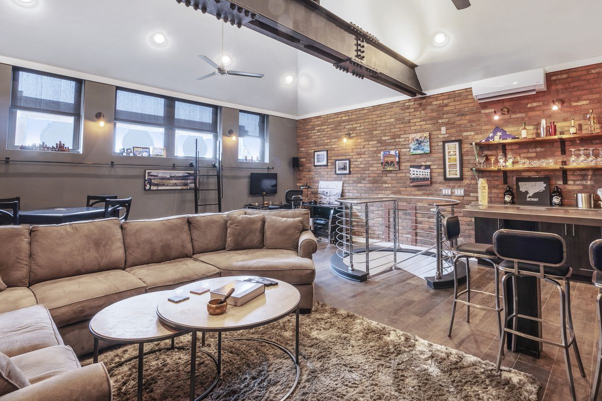 Second-story loft with exposed brick and bar.