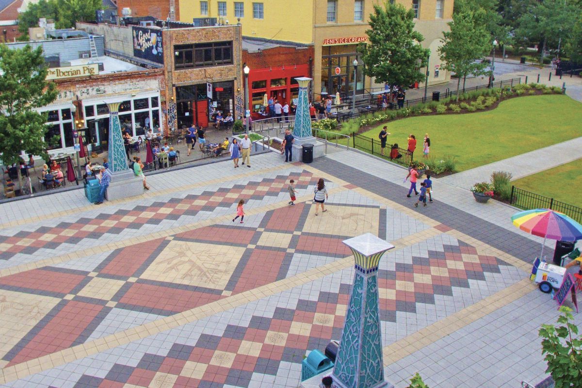 The colorful historic town square in Decatur, GA, includes restaurants with street-side patios, a gazebo, and a large paved stone area in the center for events.
