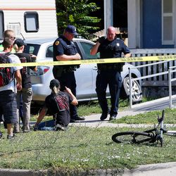Salt Lake police officers talk to a people at the scene of a shooting at 757 W. 200 North in Salt Lake City on Tuesday, Aug. 15, 2017. Police say a suspect was taken into custody at 800 North and North Temple.