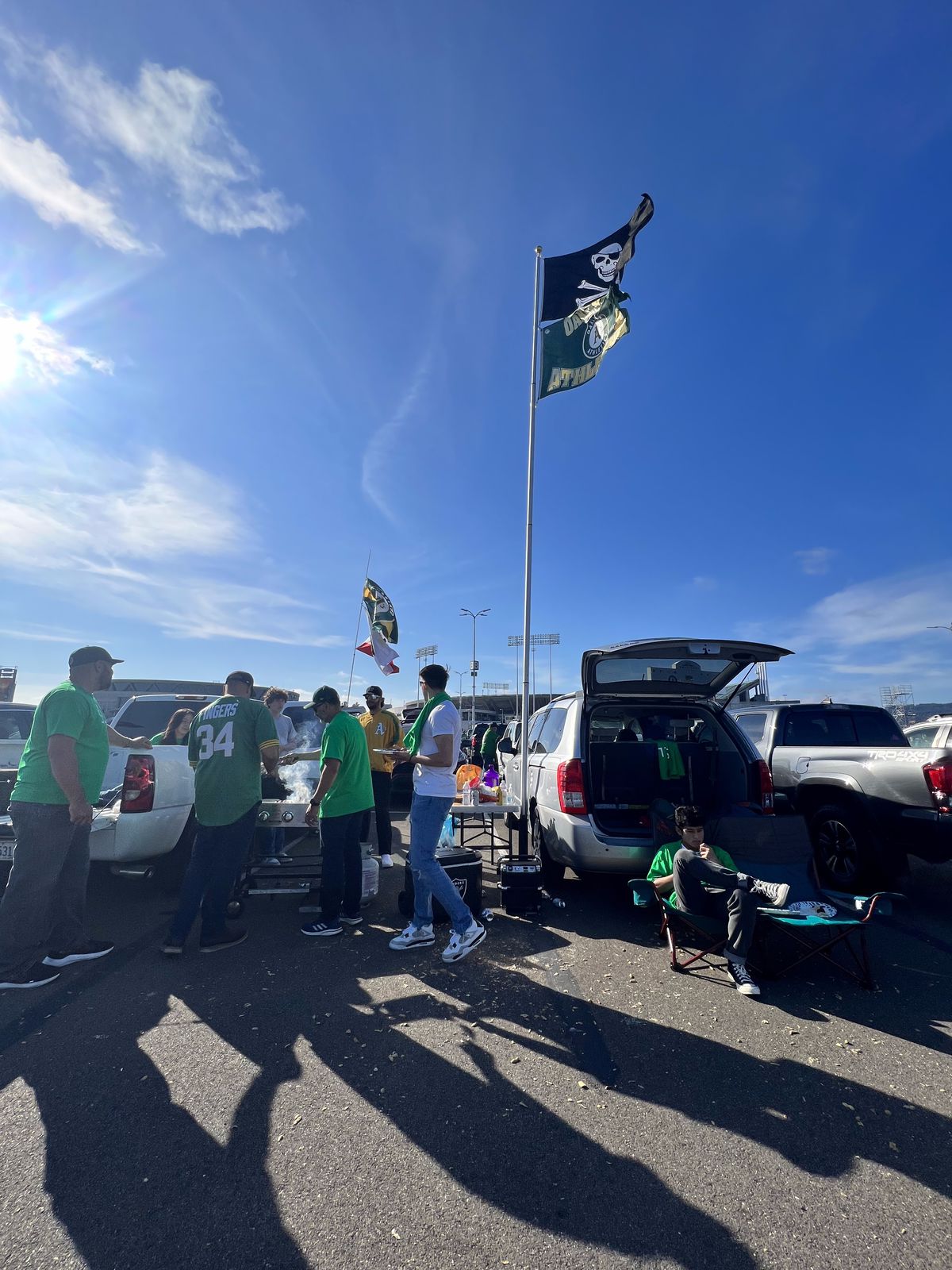 A tailgate setup including flags for the Oakland Raiders and A’s.