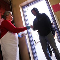 Volunteer Christine Atias hands out meal tickets to the homeless at St. Vincent de Paul's Dining Hall in Salt Lake City on March 11, 2016. 