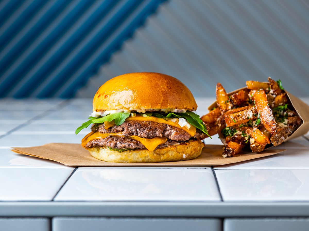 Swizzler’s “Swizz Stack” (grass-fed beef, arugula, dill pickle, stack sauce) and Parmesan truffle fries.